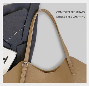 Detail of adjustable wide shoulder strap on khaki pebble leather tote with silver buckle