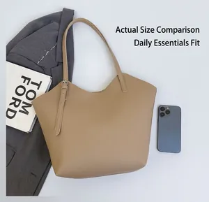 Size comparison of large khaki tote bag with a phone and book on white fabric