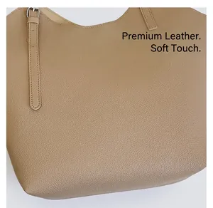 Close-up of khaki pebbled leather texture and adjustable strap on a large tote bag