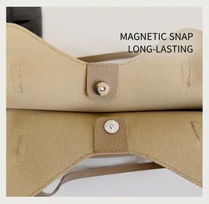 Detail view of the secure silver magnetic closure on a khaki faux leather tote bag
