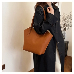 Close-up of brown pebbled leather tote bag with long shoulder straps for daily use