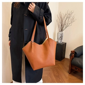Detail of the wave-shaped top edge and lychee texture of the brown tote bag