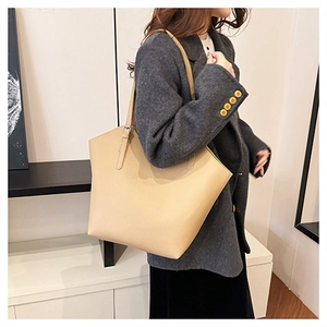 Close-up of beige lychee grain leather tote bag with adjustable shoulder strap details