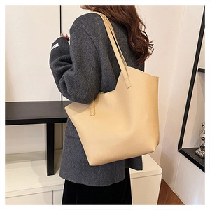 Detailed view of apricot tote bag with pebbled leather texture and wavy edge design