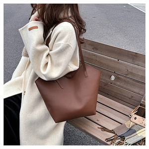 Close-up of a brown leather tote bag showing textured surface and spacious design