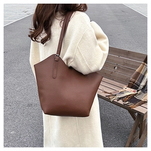 Close-up of brown litchi pattern leather tote bag with adjustable shoulder strap