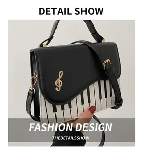 Detail view of piano key pattern print and golden treble clef embroidery on the bag