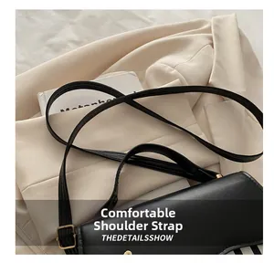 Detail of adjustable leather strap and golden hardware on the black saddle bag