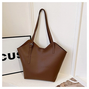Detail of a brown large capacity tote bag with lychee grain texture and metal buckle
