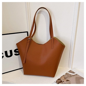 Detail of tan textured faux leather tote bag showing unique V-cut opening and strap buckle