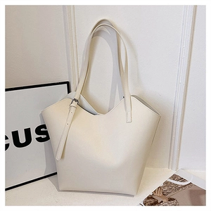 Close-up of creamy white tote bag featuring lychee texture leather and silver buckle detail