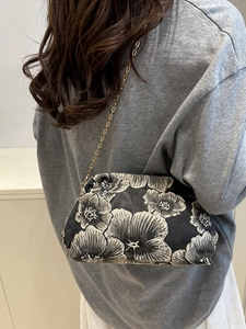 Sac bandoulière brodé de fleurs avec chaîne argentée porté par un mannequin de dos