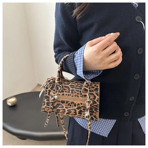 Detail of leopard print mini crossbody bag with tassels and silver metal rivets