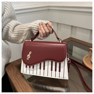 Detail view of piano key design with golden musical note on stylish handbag