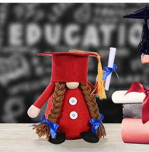 Macro shot of red graduation gnome with square cap, golden tassel and diploma scroll