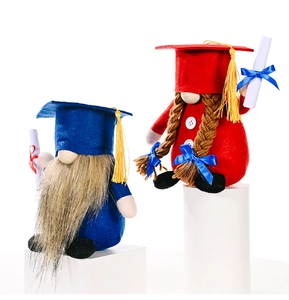 Detail of red and blue graduation gnomes with tassels and certificates on white pedestals