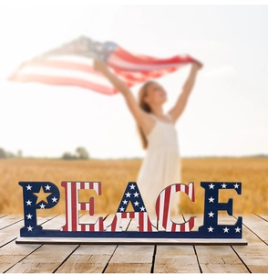 Detailed close-up of PEACE wooden letter decor with American flag pattern on wood table
