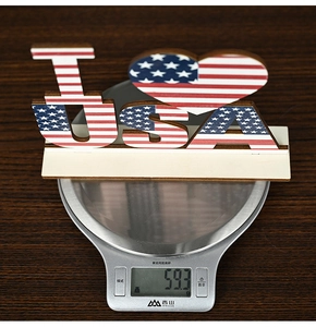 Wooden USA patriotic table sign weighing 59.3 grams on a digital scale for home decor