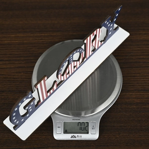 Close-up of GLORY American flag wooden sign showing net weight on a digital scale