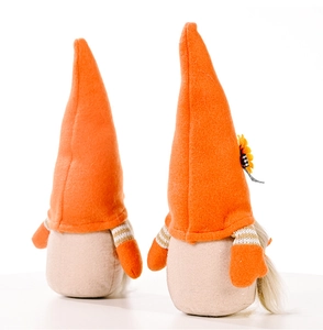 Close-up of fall gnomes with orange hats, sunflower decor, and striped sleeve details