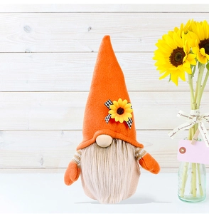 Macro detail of sunflower gnome doll with plaid bow and felt hat on wooden background