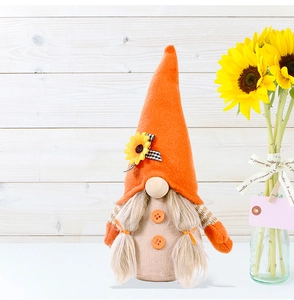 Detail of autumn gnome doll with sunflower hat, black-white bow and blonde pigtails