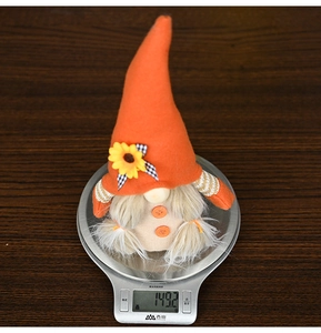Sunflower gnome plush decoration weighing 149.2g on electronic scale with wood background