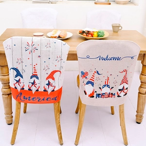 Detail of USA Independence Day chair covers with gnome designs and America text on linen fabric