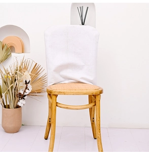 Detail of white fabric chair cover on wooden dining chair for Independence Day decor