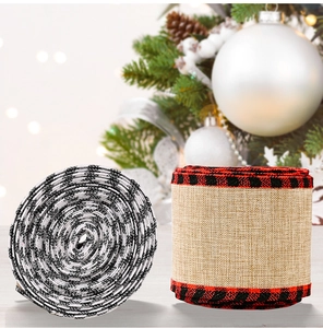 Close-up of burlap Christmas ribbons with red and black plaid edges on festive tree
