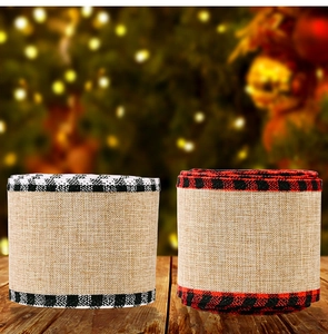 Close-up of Christmas faux burlap ribbons with red and black plaid edges on wood surface