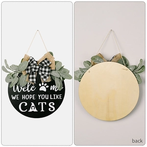 Detail view showing the black wooden cat welcome sign with a buffalo plaid bow and green leaves