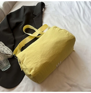 Detailed macro view of yellow waterproof nylon cylinder sports bag with white stripes