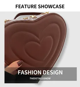Close-up of brown heart-shaped leather bag with embossed concentric layers and gold zippers