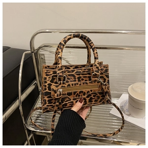 Close-up of leopard print handbag featuring silver hardware and decorative tassel detail