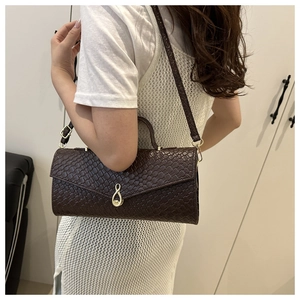Détail du sac bandoulière marron foncé tressé avec fermoir doré en forme de huit