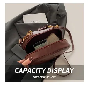 Macro view of dark brown PU leather crossbody bag showing internal storage capacity