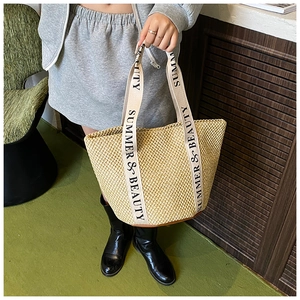 Détail du sac seau en paille avec poignées Summer & Beauty et finition en cuir brun