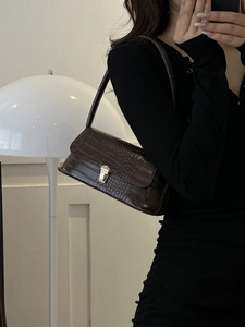 Borsa a spalla retrò marrone scuro con trama coccodrillo e chiusura dorata indossata