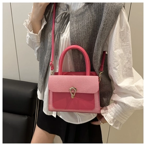 Detail of the elegant red and white striped flap with horse-shoe buckle on the handbag