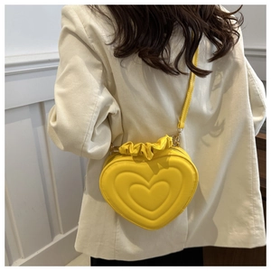 Detail of yellow heart-shaped crossbody bag with ruffled edges and concentric stitching
