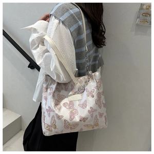 Détail d'un sac cabas imprimé papillon avec bandoulière cuir et chaîne métal
