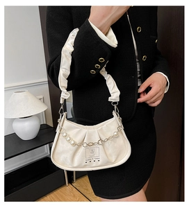 Détail du sac à bandoulière blanc plissé avec perles et chaîne de décoration en cœur