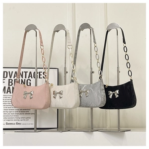 Detail of four colorful pleated shoulder bags with metallic bow and acrylic link straps