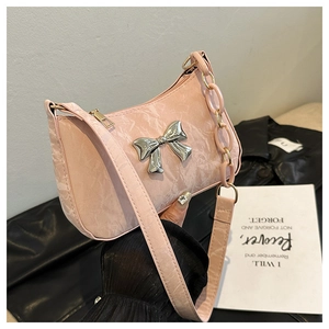 Detailed view of pink shoulder bag with marble texture and silver metallic bow detail