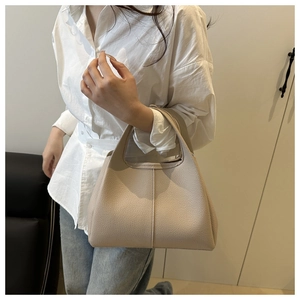 Detail der beigen Handtasche aus Leder mit Litschistruktur im modernen Wohnambiente