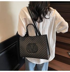 Gros plan d'un sac cabas vintage avec motif M et logo en relief sur un mannequin