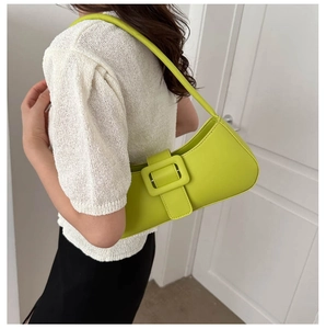 Vue détaillée du sac baguette vert fruit avec grande boucle carrée sur un modèle