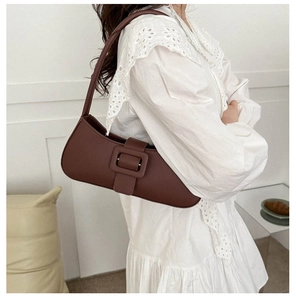 Détail du sac baguette en cuir marron foncé avec boucle carrée sur la bandoulière