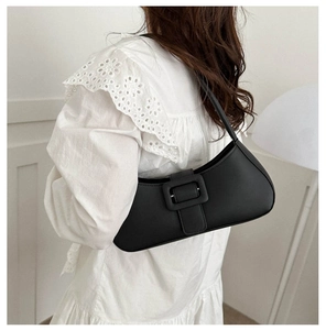 Mannequin portant un sac sous le bras en cuir mat noir avec grande boucle carrée